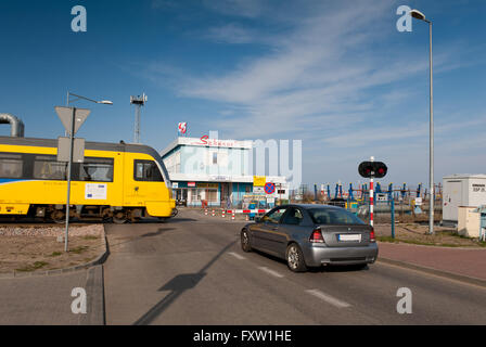 Téléphérique et passage à niveau fermé avec barrière de fer de flèche, et le véhicule en attente devant Szkuner dans immeuble Wladyslawowo. Banque D'Images