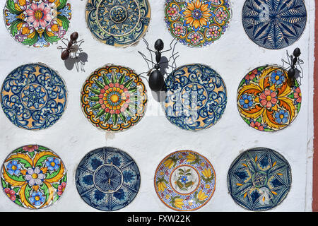 Affichage des plaques en céramique peint à la main et des fourmis en métal à décorer la paroi d'une boutique de souvenirs, Gata de Gorgos, Valence, Espagne. Banque D'Images