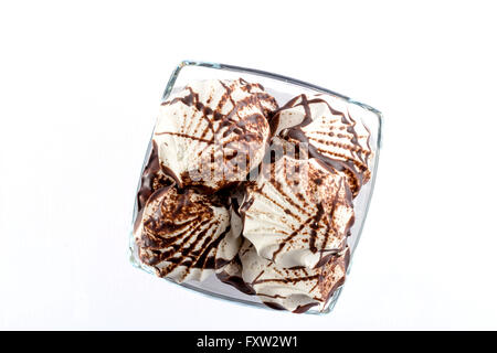 Guimauves blanc recouvert de chocolat dans une tasse en verre isolé sur fond blanc Banque D'Images