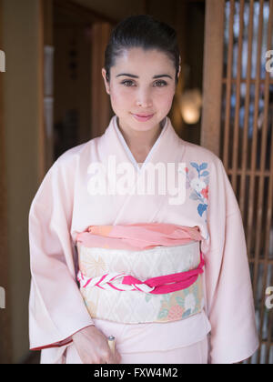 Kimono japonais femme portant pas hors d'une maison traditionnelle de Kyoto, Japon Banque D'Images