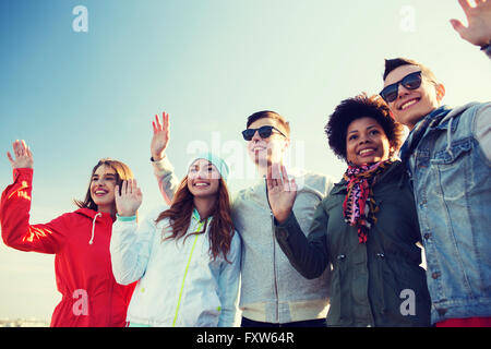 Heureux amis adolescents dans les tons des signes avec la main Banque D'Images