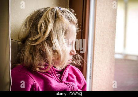 Jolie petite fille à la recherche d'une fenêtre Banque D'Images