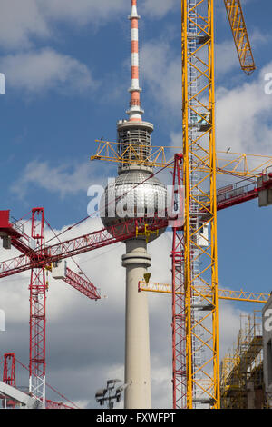 La tour de télévision de Berlin derrière les grues de construction. La tour de télévision est le monument le plus célèbre de Berlin. Banque D'Images