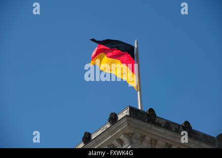 Berlin, Allemagne. 18 avr, 2016. Le drapeau allemand battant au sommet du bâtiment du Reichstag contre un ciel bleu ensoleillé, à Berlin, Allemagne, 18 avril 2016. Photo : PAUL ZINKEN/DPA/Alamy Live News Banque D'Images