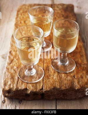 Verres de vin blanc sur la planche à découper en bois Banque D'Images
