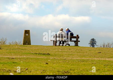 Vieux couple actif de marcheurs assis sur un banc près de trig point Banque D'Images