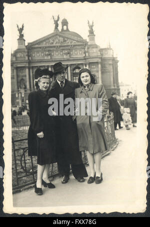 Un homme et deux jeunes femmes sur un arrière-plan du théâtre d'opéra et de Ballet, Lviv, URSS. Photo d'archives, 1950 Banque D'Images