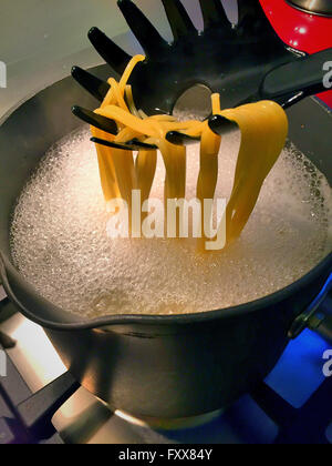 L'eau bouillante sur la cuisson des pâtes cuisinière en cuisine Banque D'Images