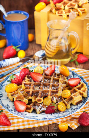 Gaufres de potiron belge avec des fraises fraîches, kumquat, miel et tasse de café Banque D'Images