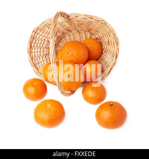 Panier en osier rempli de plusieurs frais mûrs juteux tangerines, isolé sur la composition fond blanc Banque D'Images