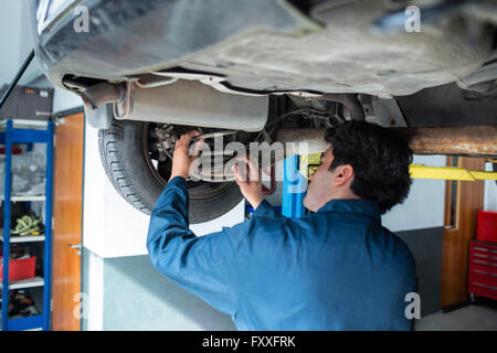 Mechanic repairing suspension d'une voiture Banque D'Images