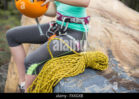 Midsection of woman holding helmet on rock Banque D'Images