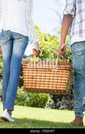 Couple carrying picnic basket Banque D'Images