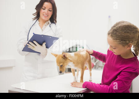 Jeune fille tenant son chien pendant l'examen de l'EFP Banque D'Images