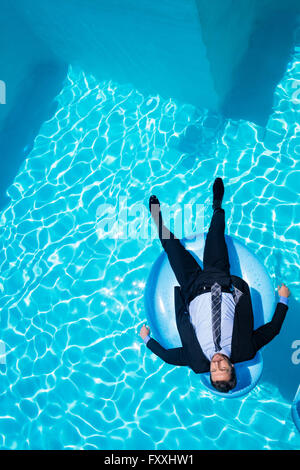 Businessman relaxing on inflatable Banque D'Images