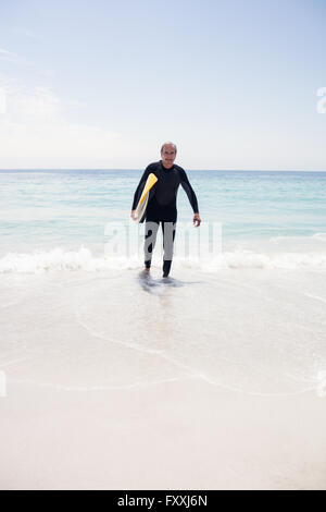 Man wetsuit holding a surfboard Banque D'Images