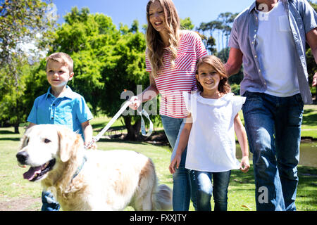 Balades en famille dans le parc avec leur chien Banque D'Images