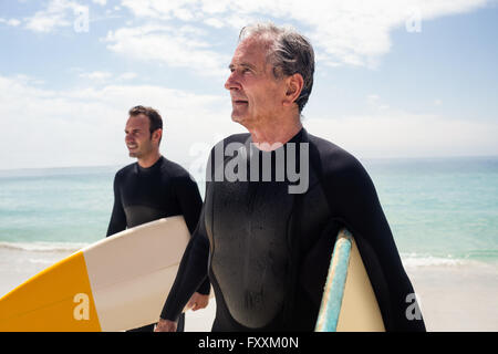 Père et fils debout avec surf et à la recherche à une distance Banque D'Images