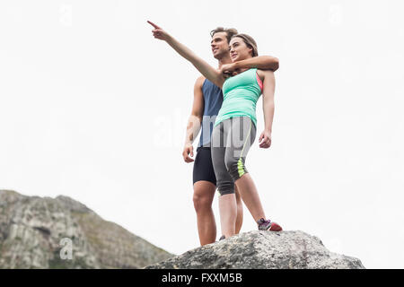 Tout en pointant la femme homme debout sur la roche Banque D'Images