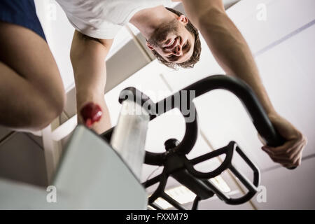 Man working out on exercise bike at spinning class Banque D'Images