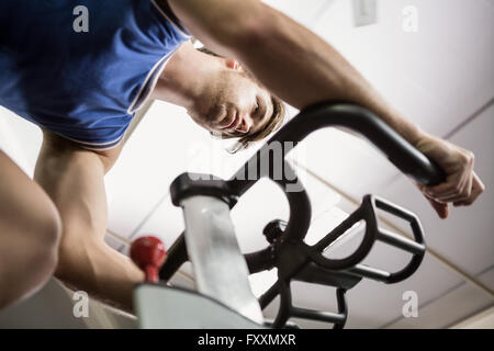 Man working out on exercise bike at spinning class Banque D'Images