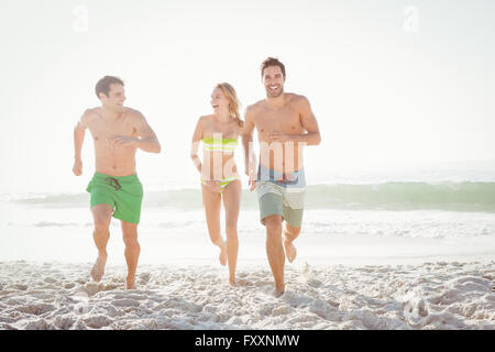 Happy friends s'exécutant sur la plage Banque D'Images