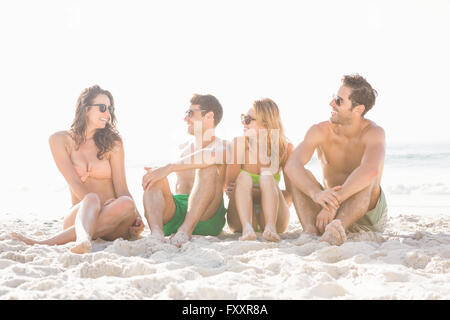 Happy friends sitting on the beach Banque D'Images