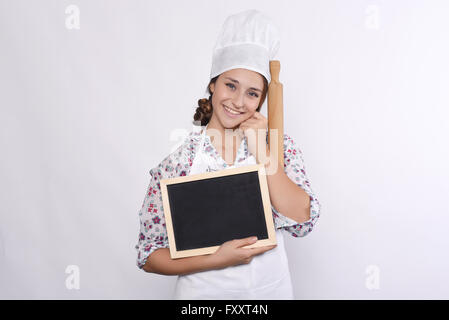 Jeune femme chef avec menu vide tableau noir et de rouleau à pâtisserie. Isolé sur fond blanc. Banque D'Images