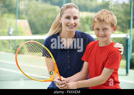 Entraîneur de tennis féminin donnant Leçon pour garçon Banque D'Images