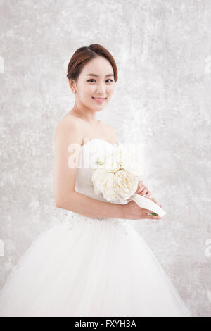 Bride holding bouquet et regardant vers l'avant avec un sourire Banque D'Images