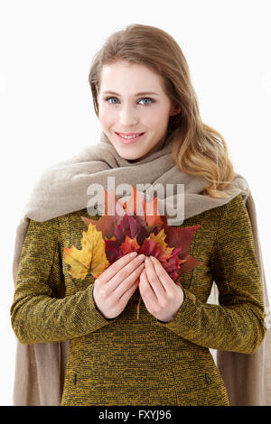 Femme en tenue de silencieux jusqu'à feuilles d'érable représentant l'automne Banque D'Images