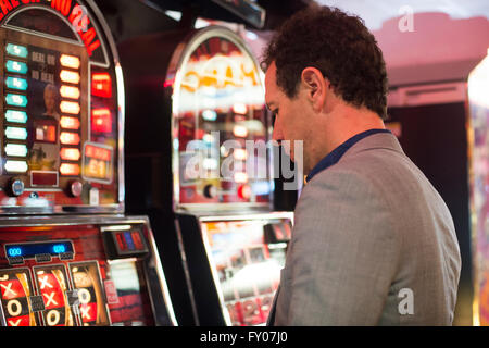 L'homme en jeu casino avec machines à sous à perdre de l'argent Banque D'Images