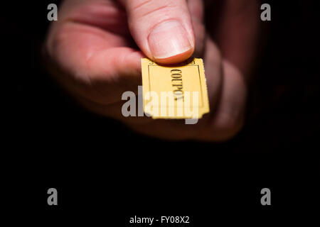 Un homme de main droite tenant un carton jaune à 7 chiffres du ticket marqué avec le mot "rabais" imprimé à l'encre noire Banque D'Images