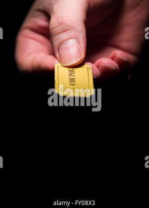 Un homme de main droite tenant un carton jaune à 7 chiffres du ticket marqué avec le mot "rabais" imprimé à l'encre noire Banque D'Images