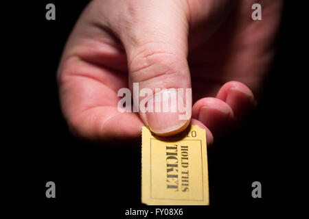 Un homme de main droite tenant un carton jaune à 7 chiffres du ticket marqué de la mention " Conserver ce ticket' à l'encre noire Banque D'Images