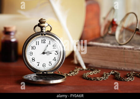 Vintage still life. Montre de poche près de faire défiler et d'autres choses vintage Banque D'Images