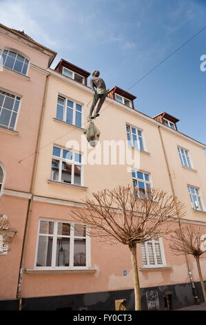 Sculpture d'un pêcheur à pied d'équilibrage sur la corde entre deux bâtiments accessoires extérieurs à Sopot, funambule holding net. Banque D'Images