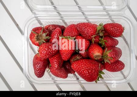 Le carton rempli de fruits rouges fraises sur une table en bois. Crète, Grèce Banque D'Images