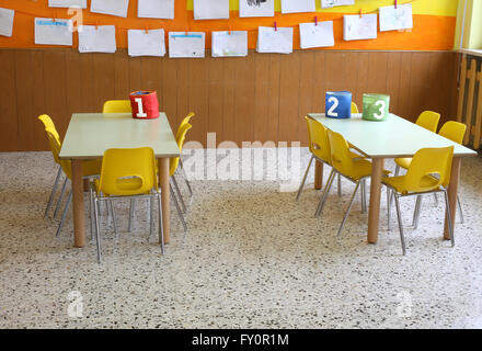 Classe de maternelle avec les chaises jaunes et de nombreux dessins d'enfants sur les murs Banque D'Images