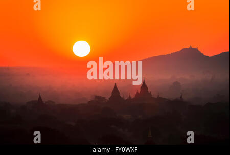 Lever de soleil sur l'horizon et temples de brume du matin, à l'ancienne Bagan avec orange sky temple et silhouettes, Myanmar (Birmanie) Banque D'Images