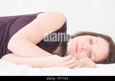 Femme endormie. Portrait de jeune femme couchée dans son lit avec les yeux fermés, se reposer. Banque D'Images