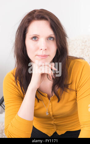 Portrait de femme en blouse jaune, looking at camera. Une femme confiante exprimant la fierté. Banque D'Images