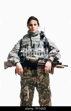 Portrait de femme soldat debout avec rifle contre fond blanc Banque D'Images