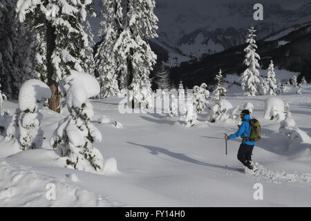 Homme marchant sur les montagnes couvertes de neige contre champ Banque D'Images