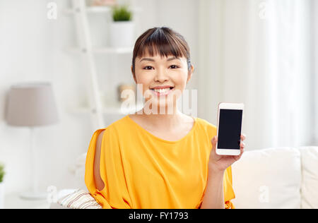 Happy asian woman showing smartphone à Accueil Banque D'Images