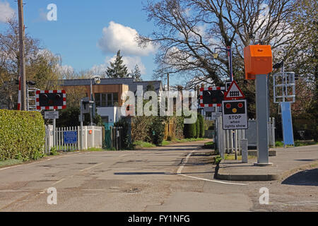 Une barrière de passage à niveau automatique de la moitié en zone rurale avec beaucoup de signalisation et antérieus de chaque côté de l'appareil photo. Banque D'Images