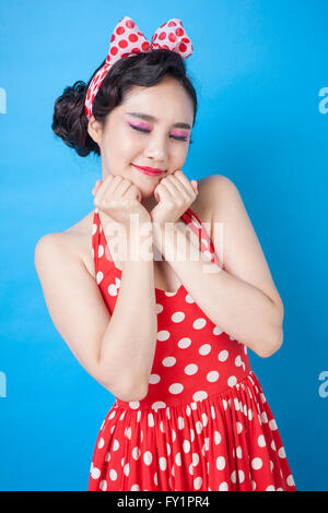 Young smiling woman in retro style placer son menton sur ses mains fermer les yeux Banque D'Images