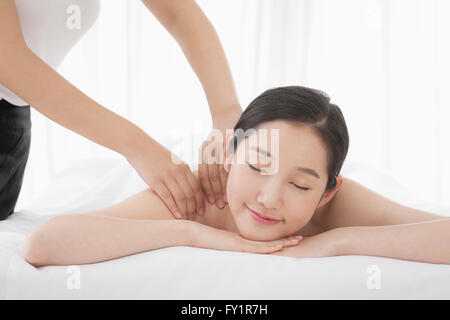 Portrait of young smiling woman getting massage fermant les yeux Banque D'Images