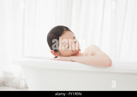 Portrait of young woman relaxing in a tub fermer les yeux Banque D'Images