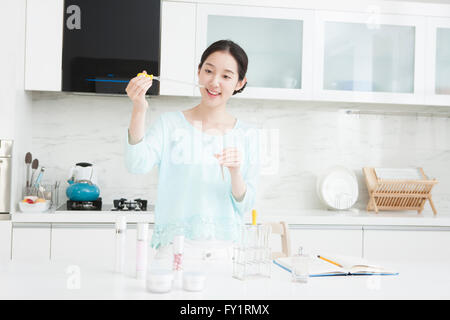 Young smiling woman doing experiment in kitchen Banque D'Images